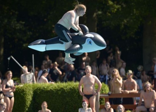 A Heavy Metal fan, sitting on a plastic whale float, jumps into a swimming pool during the 24th Wacken Open Air Festival in Wacken, August 2, 2013.  (Fabian Bimmer/Reuters)